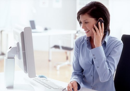 woman on phone at computer - Contract Interiors, IN