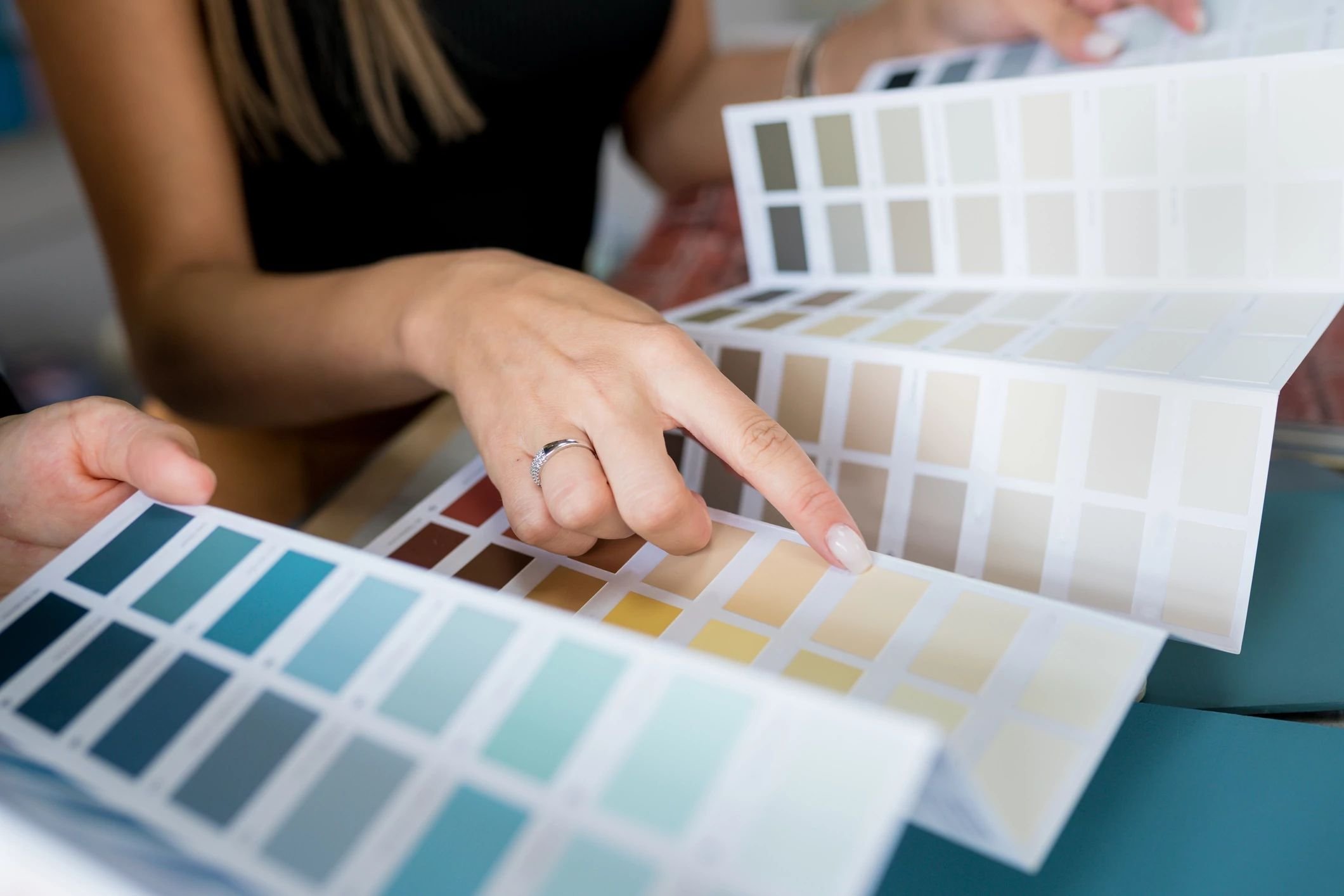 woman choosing paint color from pamphlet - Contract Interiors, IN